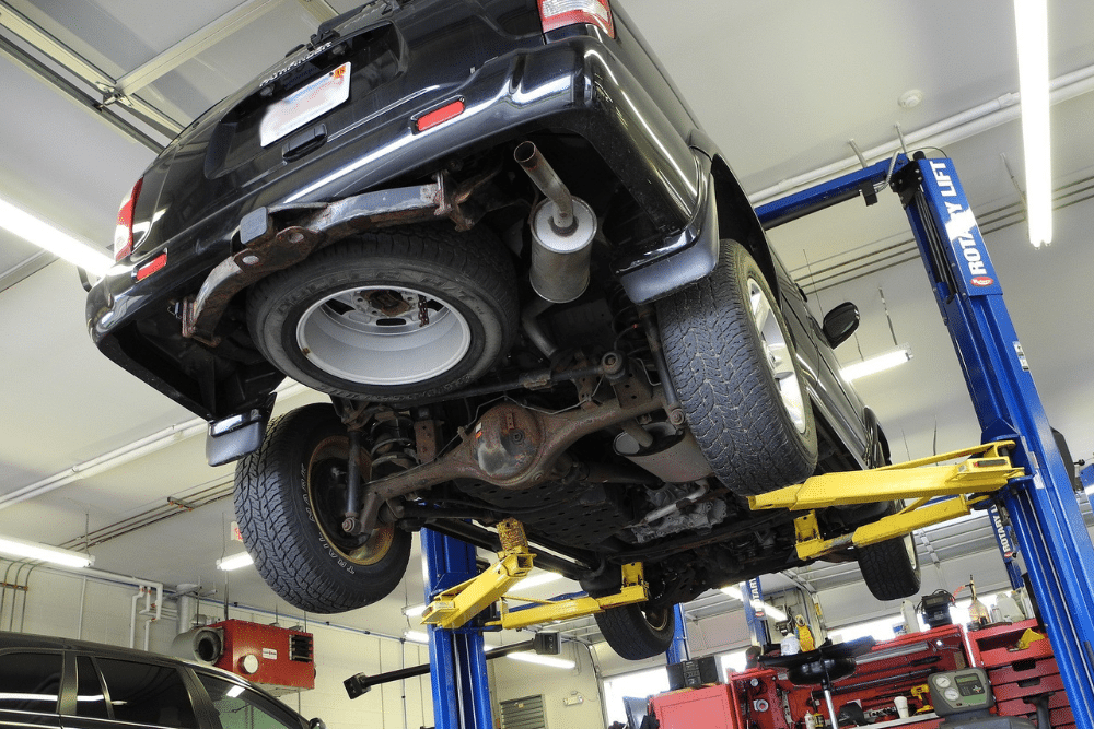 Tire Maintenance in North Little Rock, AR by Cantrell Service Center. Image of a vehicle on a lift in an auto repair shop, showcasing the underside of the car and tire inspection, emphasizing the importance of regular tire maintenance and expert care at Cantrell Service Center.