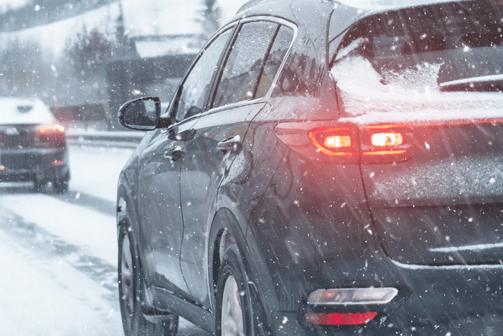 Winter car prep, auto repair in North Little Rock, AR by Cantrell Service Center. Image of a car driving in snowy conditions with tail lights visible.
